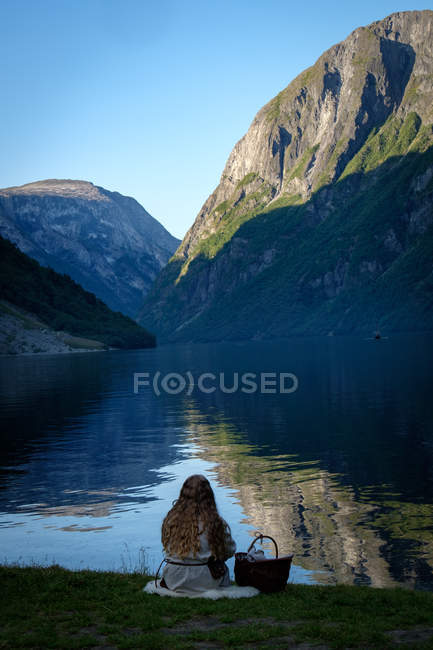 Scenic view of Girl sitting by a fjord, Gudvangen, Aurland, Sogn og Fjordane, Norway — Stock Photo