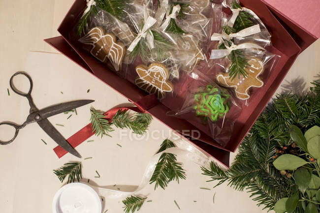 Gingerbread cookies being wrapped as Christmas gifts, top view — Stock Photo