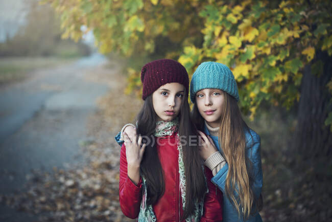 Retrato de dos chicas con los brazos alrededor. - foto de stock