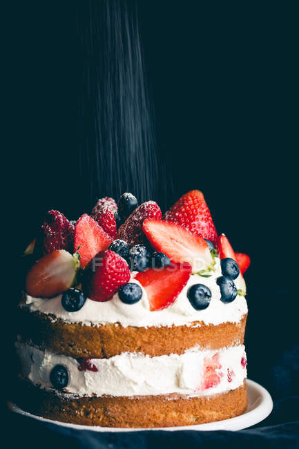 Pastel de esponja con fresas, arándanos y crema - foto de stock
