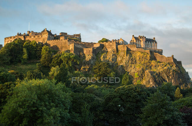 Viejo castillo en la colina verde en la luz del sol - foto de stock