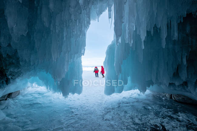 Deux femmes devant une grotte couverte de glace, Oblast d'Irkoutsk, Sibérie, Russie — Photo de stock
