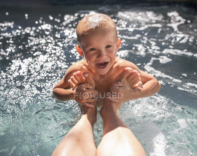 Хлопчик у басейні з ногами матері в окрузі Орандж (Каліфорнія, США). — стокове фото