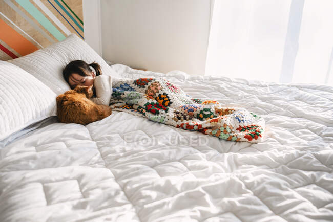Молодая девушка спит на кровати с котом — стоковое фото