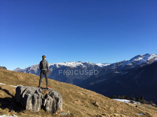 Boy standing on rocks looking at view, Braunwald, Glarus, Switzerland — Stock Photo