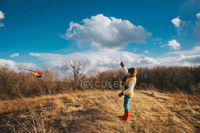Погляд хлопчика з повітрям на осіннє поле під хмарним небом. — стокове фото