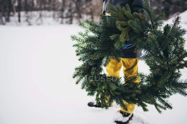 Cropped image of boy holding a Christmas wreath — Stock Photo