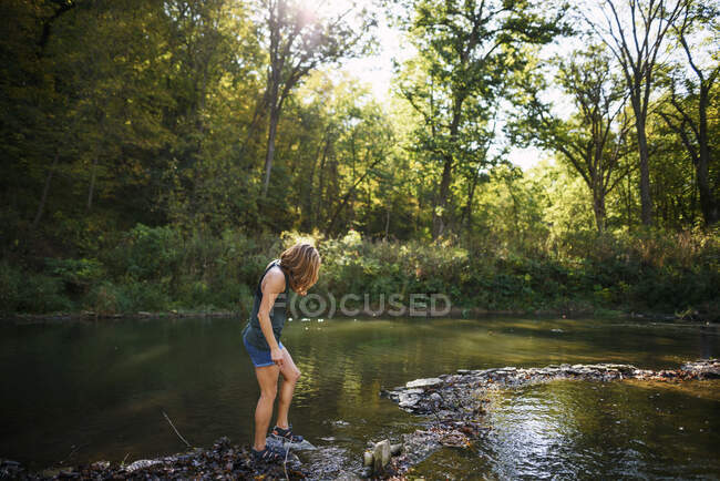 Mulher andando ao longo de uma margem do rio — Fotografia de Stock