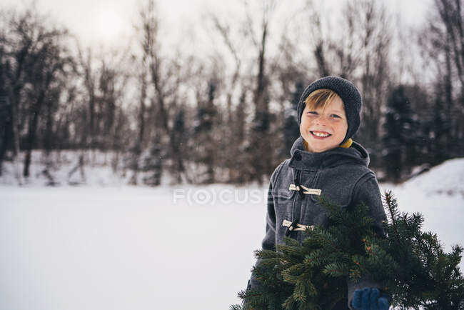 Портрет улыбающегося мальчика, стоящего в снегу — стоковое фото