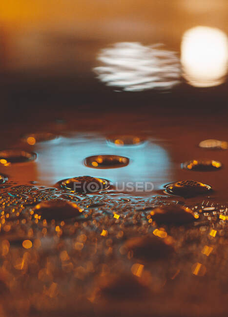 Großaufnahme von Leuchtreklamen und Lichtern, die sich in einer Pfütze spiegeln, Chicago, Illinois, Vereinigte Staaten — Stockfoto