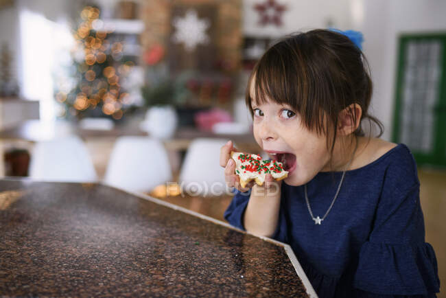 Девушка ест рождественское печенье — стоковое фото