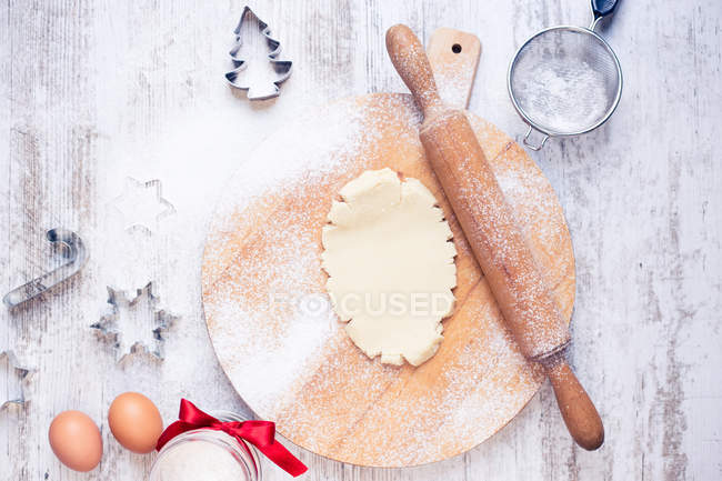 Masa de galletas, ingredientes y cortadores de galletas de Navidad - foto de stock