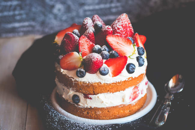 Sponge cake with strawberries, blueberries and cream — Stock Photo