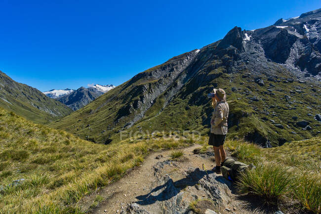 Caminhante fazendo uma pausa na água, Rees Saddle, Rees-Dart Track, Mt Aspiring National Park, South Island, Nova Zelândia — Fotografia de Stock