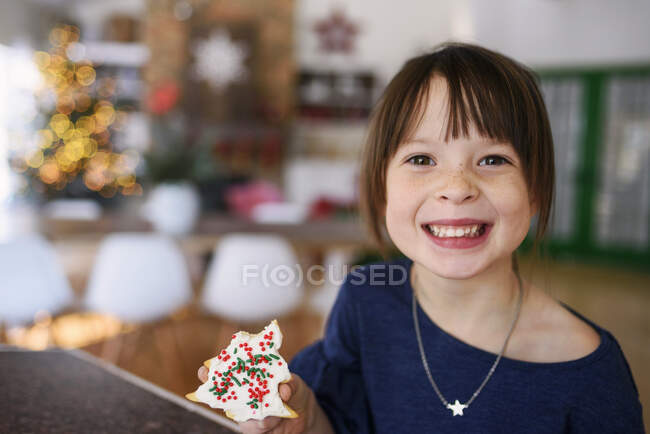 Ragazza che tiene un biscotto di Natale — Foto stock