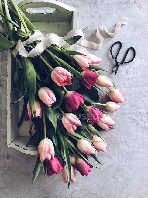 Closeup view of bouquet of tulips on a wooden tray — Stock Photo