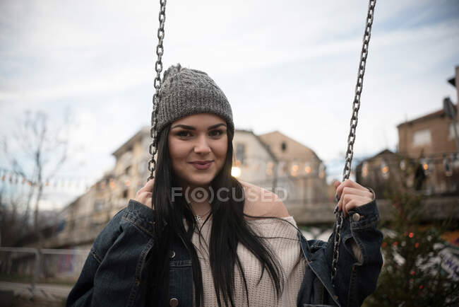 Smiling woman sitting on a swing — Stock Photo