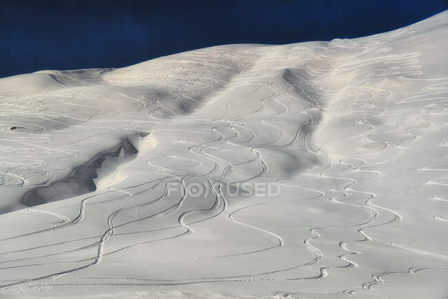 Aerial view of snowy mountains with ski tracks — Stock Photo
