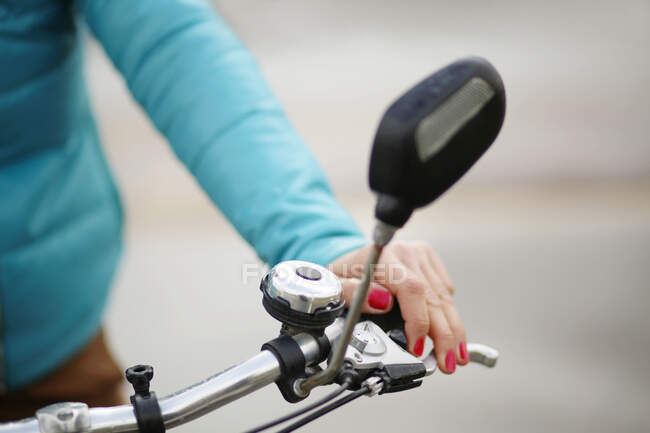 Close-up of a cyclist's hand holding the handlebars of her bike — Stock Photo
