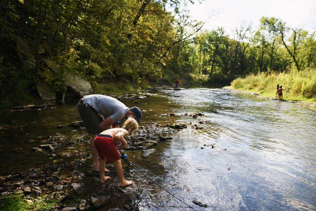 Отец и сын рыбачат в реке — стоковое фото