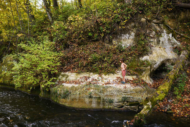 Boy standing on a riverbank on nature — Fotografia de Stock