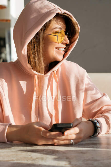 Портрет улыбающейся женщины с помощью мобильного телефона — стоковое фото