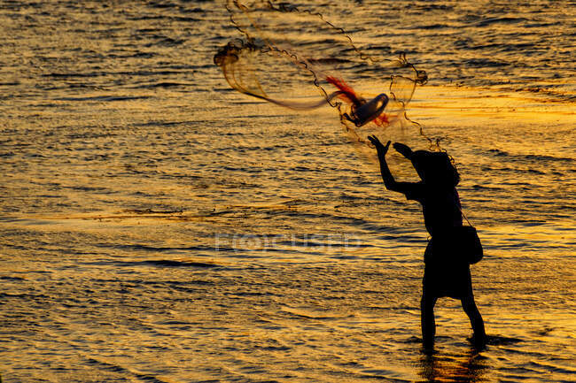 Silhouette eines Mannes mit einem Drachen am Strand — Stockfoto