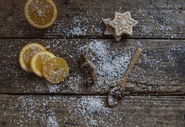 Cookies, orange slices, cinnamon and coconut with a spoon — Stock Photo