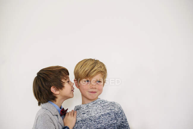 Boy whispering a secret to his brother — Stock Photo