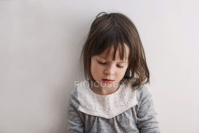 Young girl sitting in time out with wihite background — Stock Photo