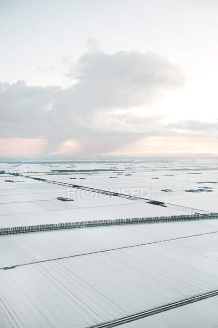 Повітряний вид на снігові покриті сільськогосподарськими полями в похмурий день — стокове фото