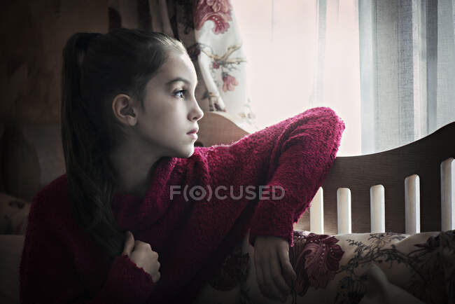 Girl looking through the window — Stock Photo