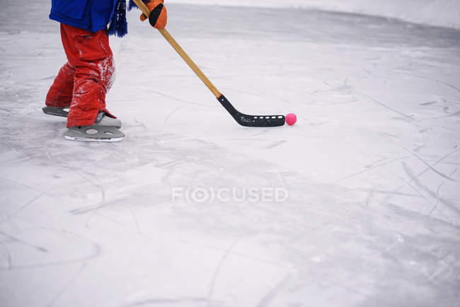 Vista de cerca de un niño piernas jugando hockey sobre hielo - foto de stock