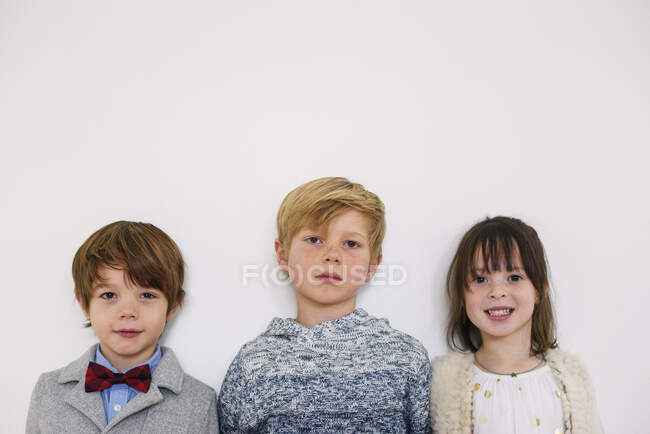 Retrato de tres niños listos para una fiesta - foto de stock
