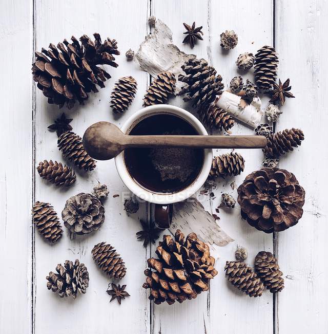 Copo de café rodeado por cones de pinho — Fotografia de Stock