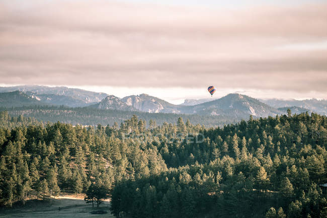 Heißluftballon fliegt über Berglandschaft, South Dakota, Amerika, USA — Stockfoto