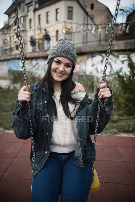 Lächelnde Frau sitzt auf einer Schaukel — Stockfoto