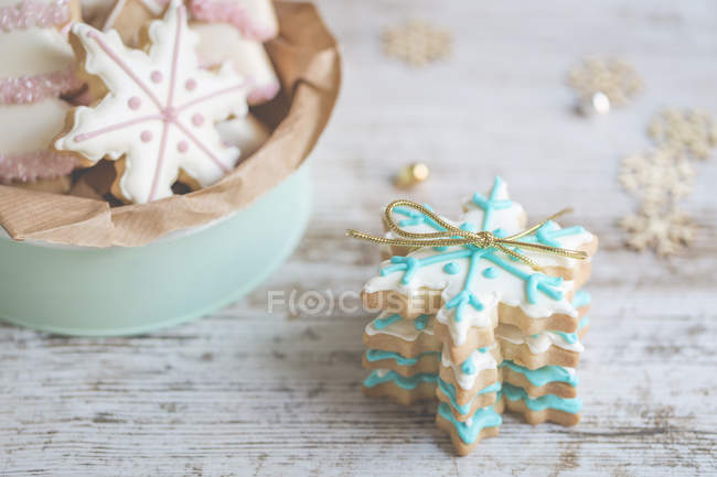 Pilha de biscoitos de Natal e tigela sobre mesa de madeira — Fotografia de Stock