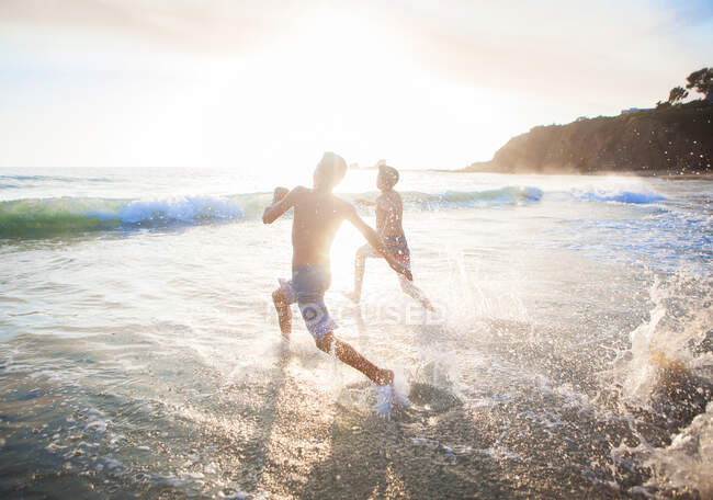 Dois meninos correndo para o oceano, Orange County, Estados Unidos — Fotografia de Stock