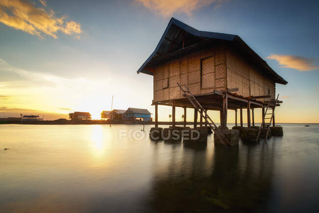 Magnifique coucher de soleil sur les cabanes de pêcheurs sur le lac asiatique — Photo de stock