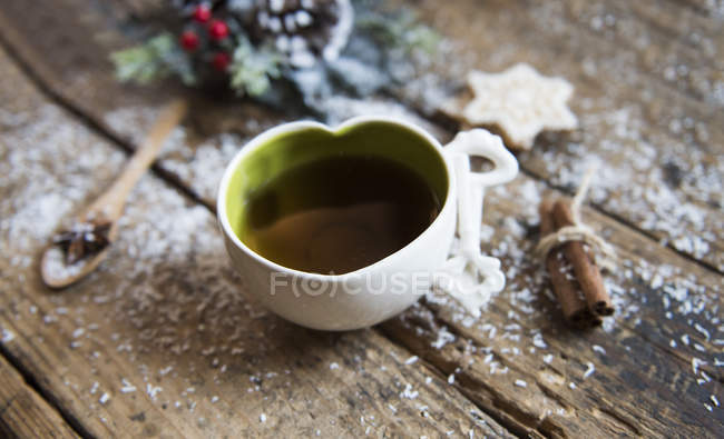 Una taza de té con canela y galletas, vista de cerca - foto de stock
