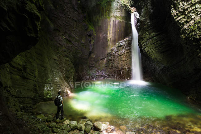 Rückansicht eines Mannes, der in der Nähe eines Wasserfalls steht, Slowenien — Stockfoto