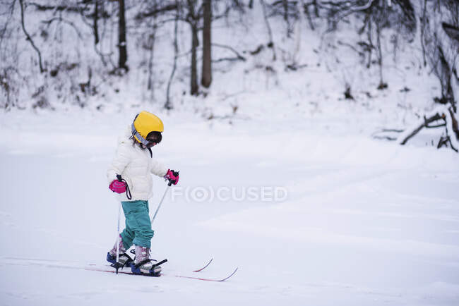 Вид збоку Дівчина катається на лижах у зимовому лісі — стокове фото