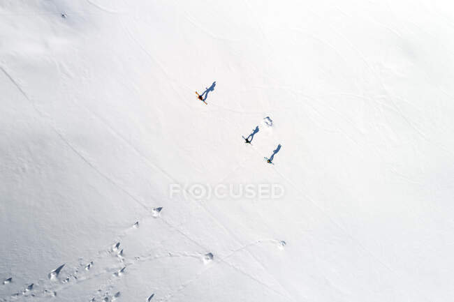 Plano aéreo de los esquiadores en la montaña nevada - foto de stock