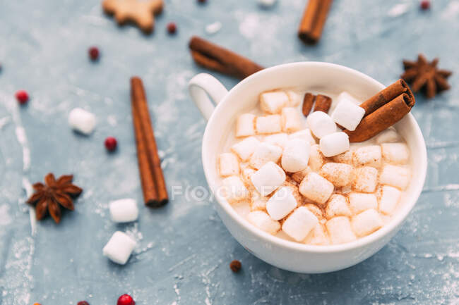 Chocolate quente com marshmallows e paus de canela em um fundo de madeira. foco seletivo. — Fotografia de Stock