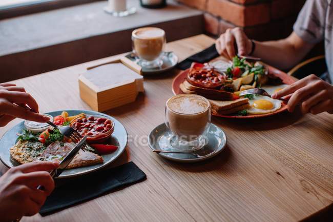 Casal comendo um ovo e bacon café da manhã — Fotografia de Stock