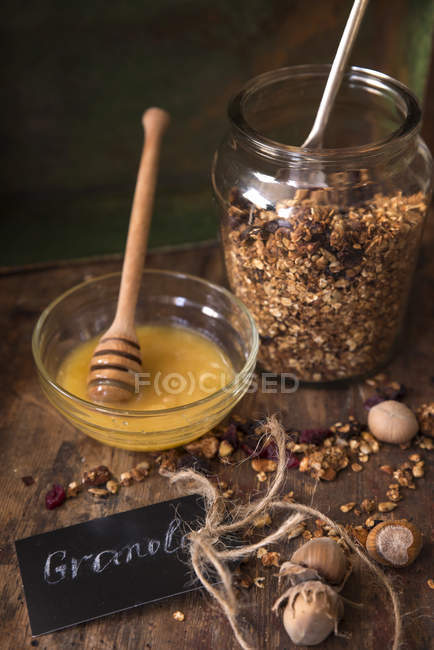 Vista de primer plano de Granola con miel sobre mesa de madera - foto de stock