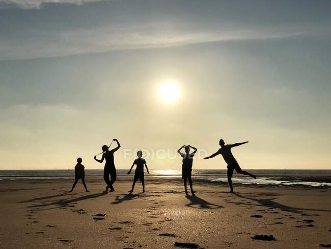 Silueta de una familia jugando en la playa, Pointe Espagnole, La Tremblade, Charente-Maritime, Francia - foto de stock