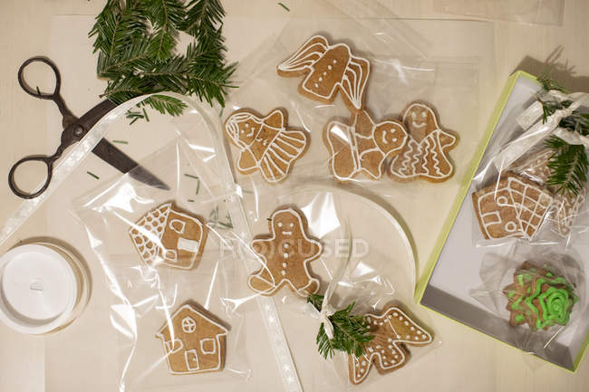 Gingerbread cookies being wrapped as Christmas gifts — Stock Photo