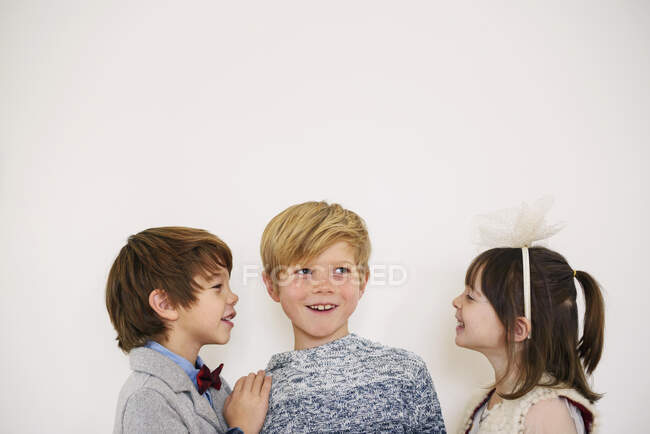 Portrait of three children in smart clothing smiling — Stock Photo